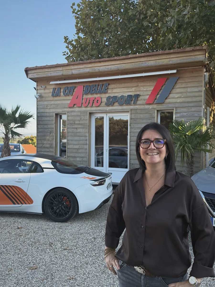 Carine Buisson devant le chalet La Citadelle Auto Sport